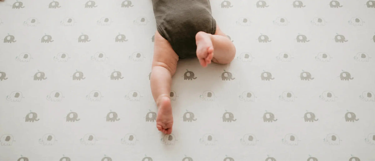 An image of a baby lying upside down in a crib