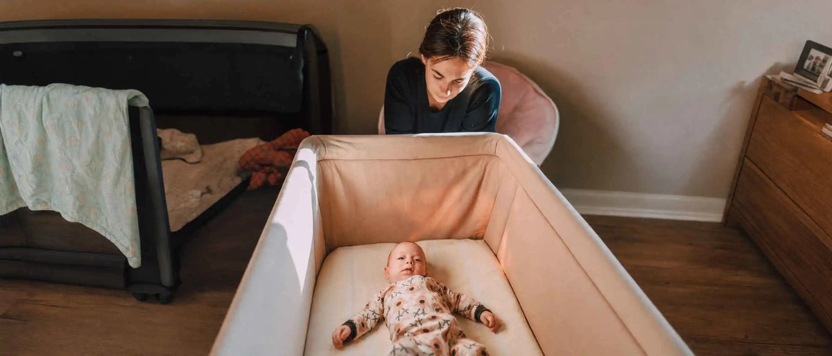 A mother looking at the baby in the crib