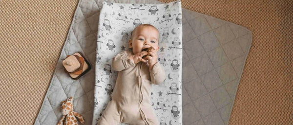 An image of a baby lying a changing pad