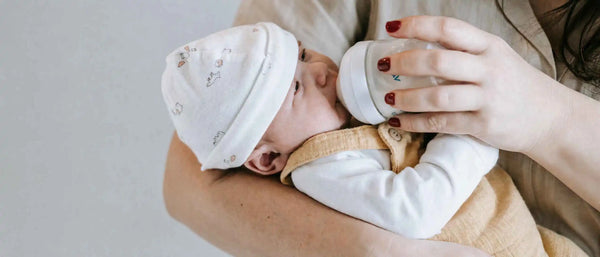 An image of a mother bottle-feeding a baby