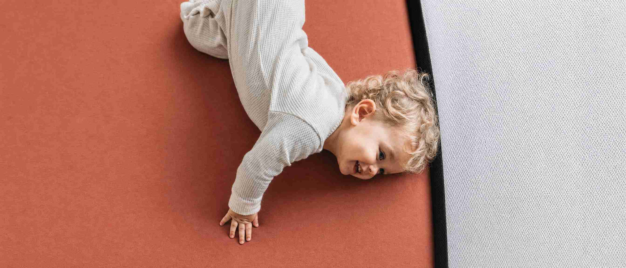 A baby playing on a breathable crib sheet