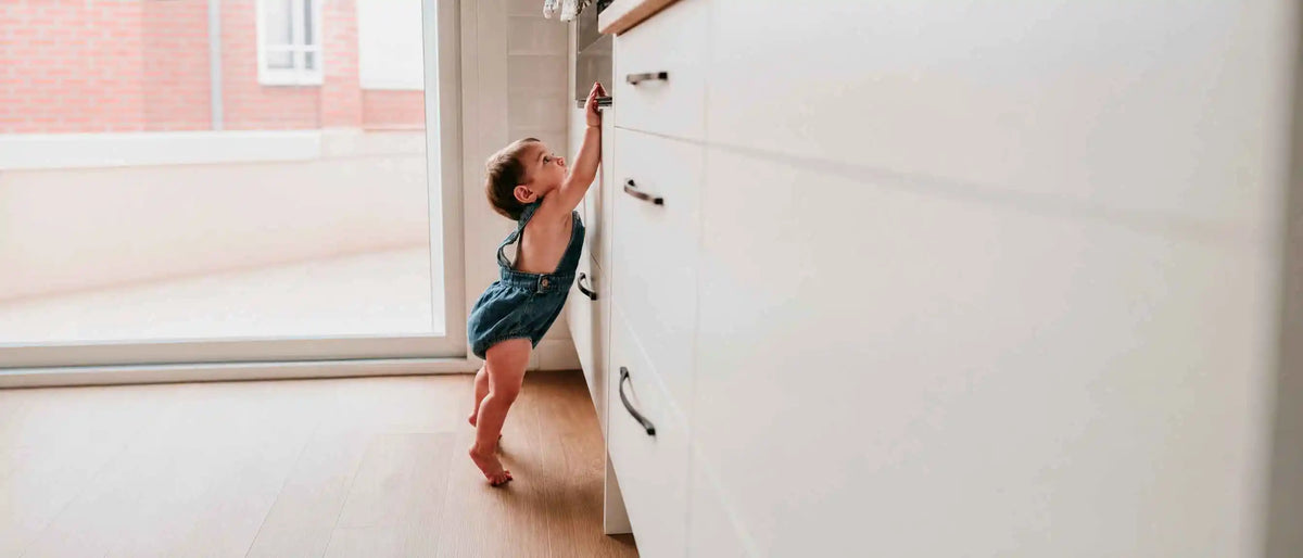 An image of a baby trying to reach the shelf