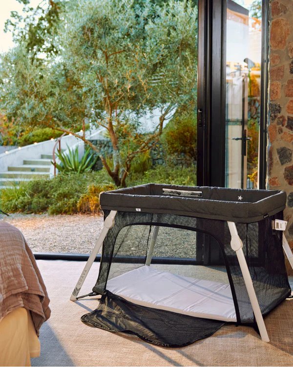 Guava Lotus Travel Crib set up beside a garden window