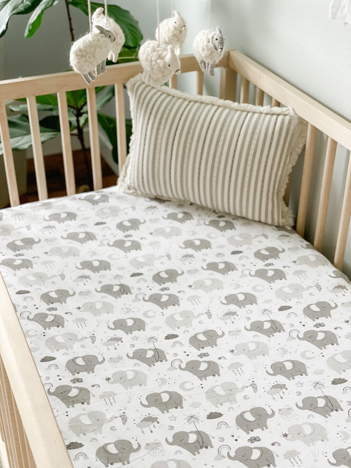 Baby sleeping peacefully on a Joey + Joan owl-print crib sheet