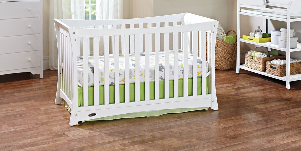 A white Graco convertible crib in a nursery