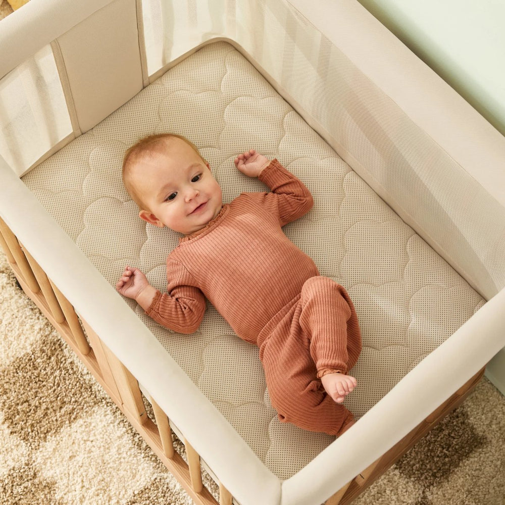 Baby lying on a soft bassinet mattress